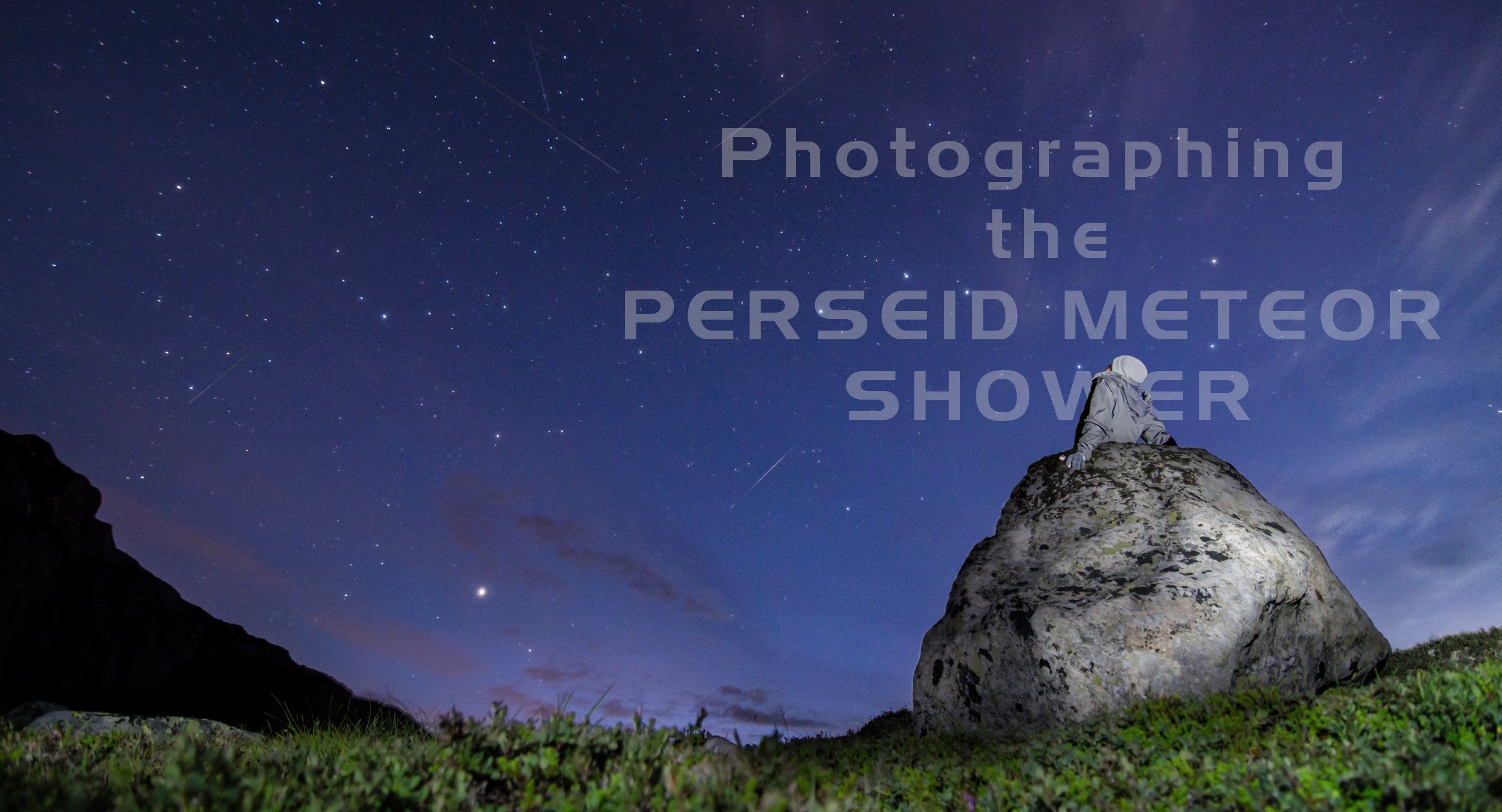 Guy sitting on a rock, photographing the perseid meteor shower